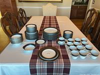 Table display of entire Noritake Mirano 78-piece china set arranged by item type