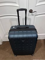 Front view of closed Samsonite suitcase showing telescopic handle and hard shell design.