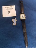 Photo of Disney Classic Pooh Eeyore women's wristwatch with black leather band and color enameled Eeyore pin displayed next to a MaxSold auction card.