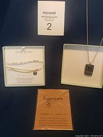 Three jewelry pieces: glass pendant necklace on chain, Capricorn pendant necklace, Paige Harper bracelet sets