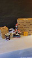 Two Jim Shore patriotic items including Uncle Sam riding a horse figurine and a candle holder, with original boxes