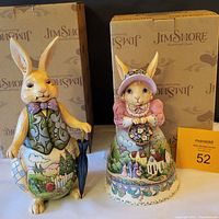 Front view of two Jim Shore bunny figurines with original boxes behind them.