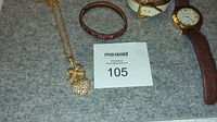 Photo showing all four items: watch, two cuff bracelets, and pendant necklace with rhinestones and bow.