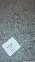Full set laid out on flat surface showing earrings, bracelet, two chains, and a smaller chain extender.