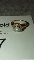 Front view of the vintage ring showing the opal stone with bright color flashes in 10K gold setting.