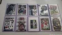 All 10 Tom Brady football cards laid out flat with card sleeves visible