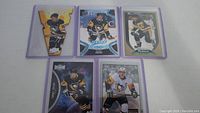 Five Sidney Crosby hockey cards arranged on a white surface, showcasing each card in detail.