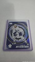 Photo of an Auston Matthews hockey trading card in protective sleeve with blue circular target design and text 'Centre of Attention'