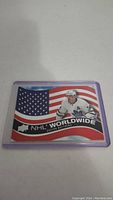 Photo of Auston Matthews NHL Worldwide hockey card inside purple plastic protector showing image of player in Leafs jersey with USA flag background.