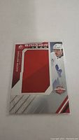 Front of Auston Matthews Banner Year jersey card showing embedded red fabric jersey piece, player image, and card details.