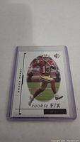 Front view of Brock Purdy rookie card with him in 49ers uniform, card number 13 of 25, encased in plastic protective sleeve.