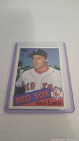 Photo of Roger Clemens rookie baseball card in a protective sleeve showing his portrait in Red Sox uniform with team name and logo.