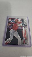 Front view of Shohei Ohtani baseball card in purple protective sleeve showing him batting for Angels.