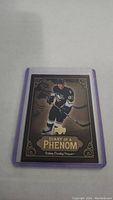 Photo of Sidney Crosby rookie hockey card featuring player in Pittsburgh Penguins uniform with decorative gold border and text 'Diary of a Phenom'. Card is in plastic sleeve.