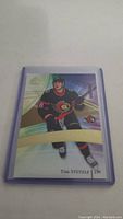 Front side of the Tim Stutzle rookie card showing the player in Ottawa Senators uniform with holographic background.