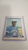 Single photo of Tony Fernandez rookie baseball card in a protective plastic sleeve, showing front of the card with player in Blue Jays uniform.