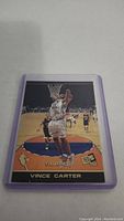 Photo of Vince Carter rookie basketball card in plastic sleeve, showing front with Vince Carter mid-dunk.