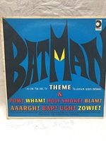 Blue album cover with large stylized 'Batman' logo and colorful comic sound effects text.