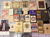 Overview of 27 vintage royal memorabilia items, primarily certificates, pamphlets, commemorative booklets, and photographs related to King George VI, Queen Elizabeth II, and other royal themes. Includes colorful royal crests and official insignia.