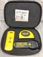 Set in open black zippered case showing laser level, stud finder, and yellow level tool in foam insert.