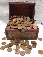 Front view of the jewelry box filled with copper pennies, some coins spilling out.