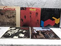 Five rock vinyl albums displayed showing front covers of Gowan Strange Animal, The Animals Greatest Hits, Foreigner, and two Refugee albums