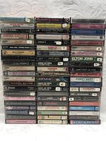 Full view of 63 rock and soft rock cassette tapes stacked in several columns showing a variety of artists and albums.
