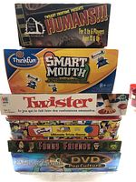 Seven board and trivia games stacked, showing game titles and edition details