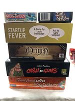 Stack of five board games showing titles and box art for identification
