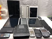 Lot overview showing multiple tablets, cell phones, and a Sony multi-function DVD recorder arranged on a surface.