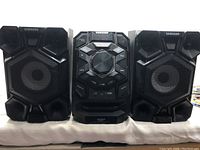 Front view of the Samsung GIGA SOUND audio component system including left and right speakers and central unit.