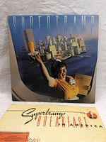 Front cover of Supertramp's "Breakfast In America" album showing waitress with breakfast items arranged like a cityscape.
