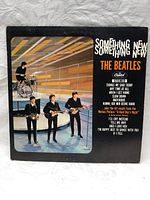Front cover of 'Something New' album by The Beatles with photo of band and track titles.