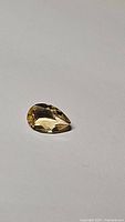 Photo of 1.18ct natural AAA golden citrine pear cut gem on plain background
