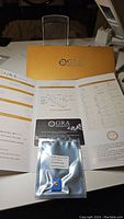 GRA certificate and packaging shown with moissanite in anti-counterfeit sealed bag with certificate card.
