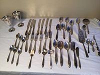 Full display of the flatware set and wine glasses on a white surface.
