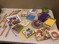 Various cocktail napkins with colorful and themed designs displayed alongside wooden utensils
