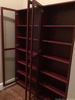 Open cherry finish cabinets revealing multiple adjustable internal shelves