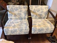 Front view of two armchairs with blue leaf pattern removable seat covers displayed.