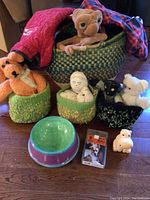 Photo showing ceramic dog bowl, knit soft bowls with toys, E.T. plush, and knit dog coats