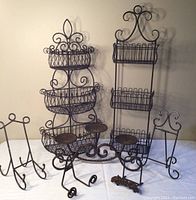 Full view of the lot showing two tiered metal baskets, three candle holder, and four small easels.