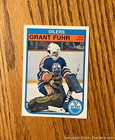 Front of the 1982-83 O-Pee-Chee Grant Fuhr rookie hockey card showing the player in goalie gear for Edmonton Oilers.