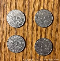 Reverse sides of four Canadian 5 cent nickels showing denomination, date, and maple leaf cluster design.
