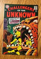 Front cover of Challengers of the Unknown #59 showing characters in yellow suits battling a giant skull creature.
