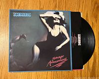 Front cover of Scorpions Savage Amusement vinyl showing woman artwork and record partially pulled out.