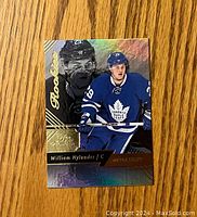 Front of William Nylander rookie hockey card showing player in Toronto Maple Leafs uniform with gold 'Rookie' foil text.