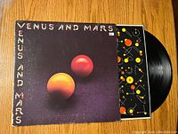 Front cover of Wings 'Venus and Mars' vinyl record showing the title and two large colorful spheres on a dark background.
