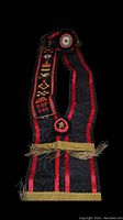 Full view of the sash showing black fabric with red stripes, metal tassels, and embroidered Masonic symbols.