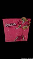Close-up of the pink side of the vintage Barbie doll box carrier showing the Barbie logo and an illustration of Barbie in a pink dress.