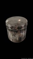 Top view of cylindrical nickel-coated brass jewelry box with rounded lid and patina.